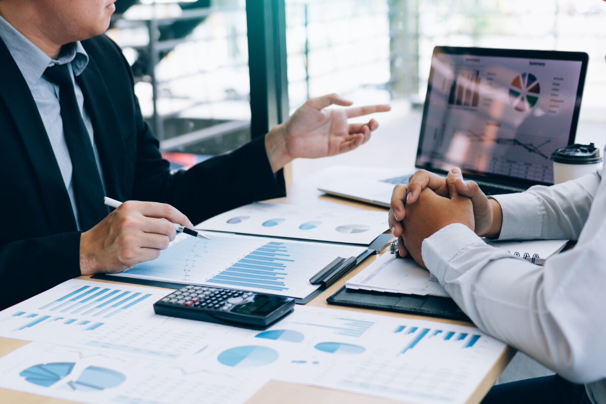 El gerente está explicando el shared cost de la empresa en la computadora portátil para que los empleados escuchen y compartan el análisis juntos.